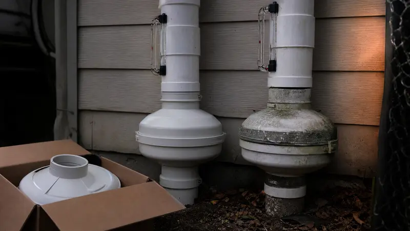 New radon fan in its box beside an old fan