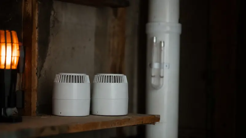 Two radon test devices side by side on a shelf