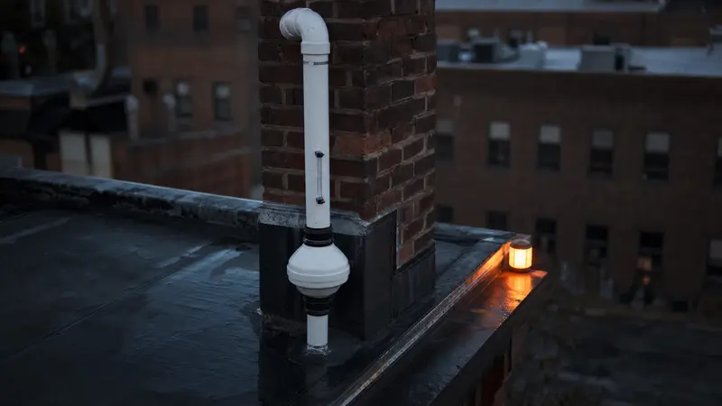 Small brick commercial building in downtown York with a rooftop radon vent pipe